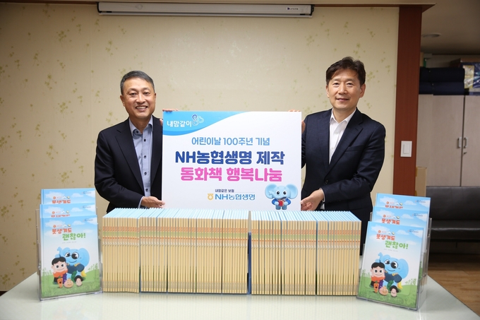 NH농협생명 경영기획부문 류영수 부사장(왼쪽)과 사단법인 행복창조 김현훈 이사장이 동화책 나눔을 기념해 사진을 촬영하고 있다. ⓒ 파이낸셜데일리 / NH농협생명