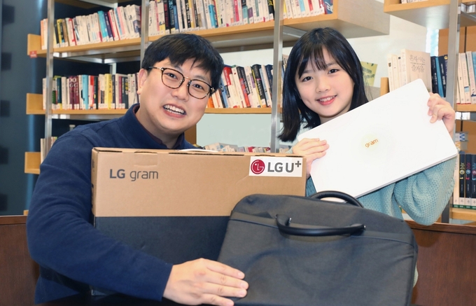 LG유플러스 임직원이 초등학교 입학을 앞둔 아동과 선물 받은 노트북을 소개하는 모습. ⓒ 파이낸셜데일리 / LG유플러스