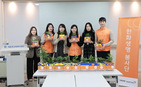 한화생명 임직원 봉사단이 만든 공기정화식물 화분을 영등포 교육복지센터에 전달했다. 한화생명 직원과 영등포 교육복지센터 직원이 함께 화분을 들고 환하게 웃고 있다. ⓒ 파이낸셜데일리 / 한화생명