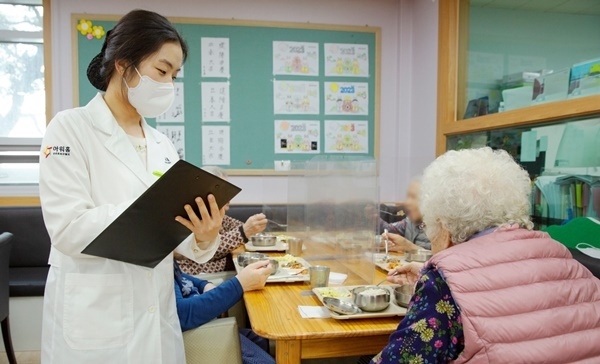 아워홈 영양사가 서울 마포구에 위치한 한서데이케어센터에서 '인지기능개선 관리 식단'을 시설 이용 어르신에게 소개하고 있다. ⓒ 파이낸셜데일리 / 아워홈