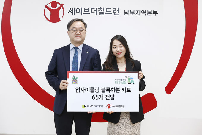 ESG마일리지 적립금으로 업사이클링 블록화분 기부 후 기념촬영 하는 김영갑 기술보증기금 이사(사진 왼쪽)와 손민지 세이브더칠드런 센터장(사진 오른쪽) ⓒ 파이낸셜데일리 / 기술보증기금