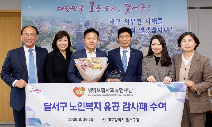 생명보험재단이 30일(목) 대구 달서구청으로부터 ‘생명숲 100세 힐링센터’ 사업 운영에 대한 공로로 감사패를 받았다. (좌측부터 김진홍 달서구 노인종합복지관장, 이지영 생명보험재단 사업추진본부장, 조태현 생명보험재단 상임이사, 이태훈 대구 달서구청장, 김보민 생명보험재단 전임, 류근현 달서구청 어르신장애인과장)