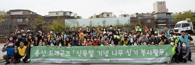 HDC현대산업개발이 식목일을 맞이해 용산구 소재 민관학 연합 봉사체 '용산 드래곤즈'와 함께 지역사회와의 상생과 환경 보호를 위한 나무 식재 봉사활동을 진행 후 기념촬영 하는 모습 ⓒ 파이낸셜데일리 / HDC현대산업개발