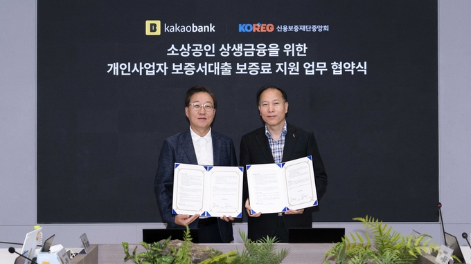 카카오뱅크 윤호영 대표(왼쪽)와 신용보증재단중앙회 이상훈 회장이 지난 16일 카카오뱅크 판교오피스에서 진행된 '소상공인 상생금융을 위한 보증료 지원 업무 협약 체결식'에서 기념 촬영을 하고 있는 모습 ⓒ 파이낸셜데일리 / 카카오뱅크
