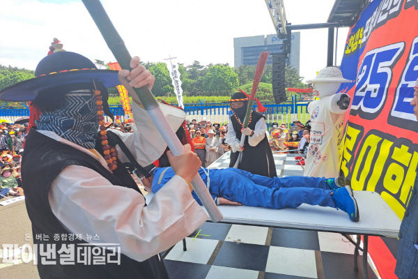 최정우회장으로 분장한 한 시민이 포졸로 분장한 포항시민으로부터 곤장을 맞고 있는 퍼포먼스를 벌이고 있다. ⓒ파이낸셜데일리/범대위