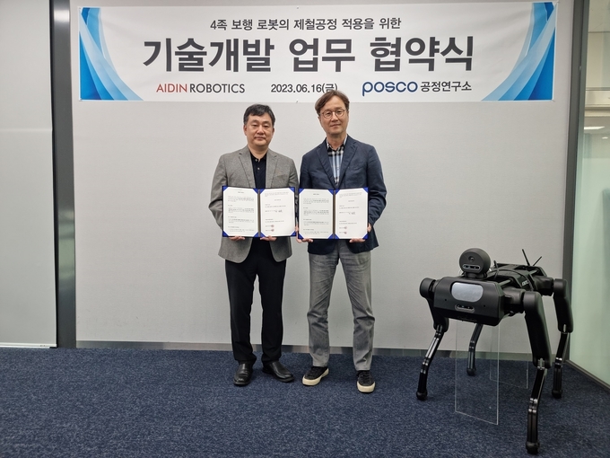 최혁렬(오른쪽) 에이딘로보틱스 대표이사와 최용준 포스코 기술연구원 공정연구소 로봇솔루션연구그룹장이 설비점검용 4족 보행 로봇 개발 협력 체계 구축 업무협약 체결 뒤 사족보행 로봇 ADIN-8와 함께 기념 촬영을 하고 있다. ⓒ 파이낸셜데일리 / 포스코