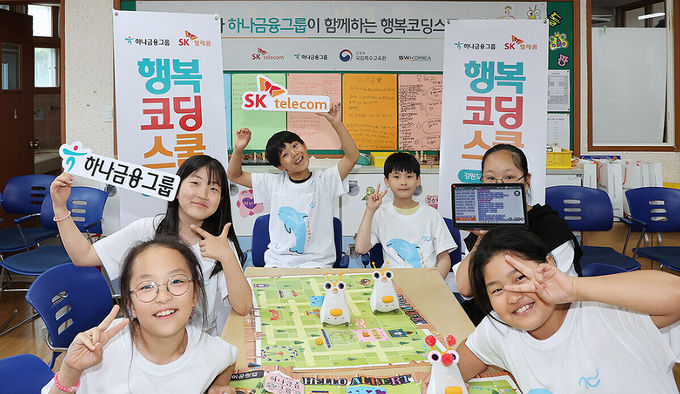 강원도 인제군에 위치한 용대초등학교에서 「행복코딩스쿨」 프로그램에 참여한 초등학생들이 코딩 로봇과 함께 포즈를 취하며 기념촬영을 하고 있다. ⓒ 파이낸셜데일리 / 하나금융그룹