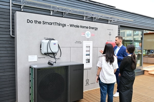삼성전자 직원이 넷 제로 홈(Net Zero Home)' 솔루션으로 꾸며진 타이니 하우스 외관에 소개된 SMA와 ABB의 에너지 생산/저장 시스템을 소개하고 있다. ⓒ 파이낸셜데일리 / 삼성전자