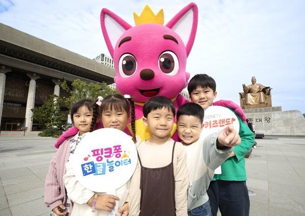 광화문 광장 세종대왕 상 앞에서 핑크퐁 캐릭터와 키즈랜드 고객이 함께 키즈랜드 오리지널 시리즈 <핑크퐁 한글 놀이터> 출시를 기념하여 촬영한 사진. ⓒ 파이낸셜데일리 / KT