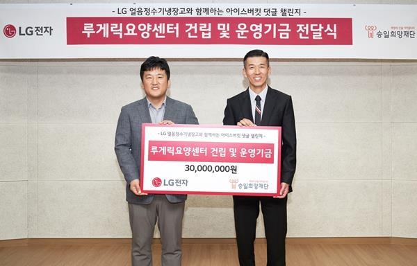 LG전자가 17일 ‘LG 얼음정수기냉장고와 함께하는 아이스버킷 댓글 챌린지’ 이벤트를 통해 모은 기부금 3천만 원을 루게릭병 환우를 위한 비영리 재단법인 ‘승일희망재단’에 전달했다. 기부금 전달식에서 LG전자 키친솔루션마케팅담당 윤성일 상무(왼쪽)와 승일희망재단 공동대표인 가수 션이 기념 촬영을 하고 있다. ⓒ 파이낸셜데일리 / LG전자