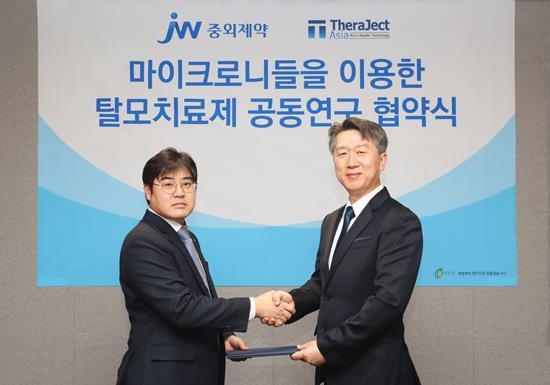 JW중외제약이 마이크로니들 연구기업 테라젝아시아와 마이크로니들 탈모치료제 공동연구 협약을 체결했다. 진세호 JW중외제약 제제연구센터장(왼쪽)과 김경동 테라젝아시아 대표이사가 협약을 체결한 뒤 기념사진을 촬영하고 있다. ⓒ 파이낸셜데일리 / JW중외제약