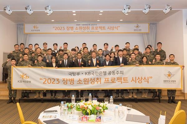 29일 서울시 용산구에 위치한 국방컨벤션에서 열린 ‘2023 장병소원성취 프로젝트’ 시상식에서 윤봉희 국방부 정책기획관(맨 앞 줄 좌측 6번째), 김동록 KB국민은행 기관고객그룹 대표(맨 앞 줄 좌측 7번째) 및 관계자들이 수상 장병들과 기념사진을 촬영하고 있다. ⓒ 파이낸셜데일리 / KB국민은행