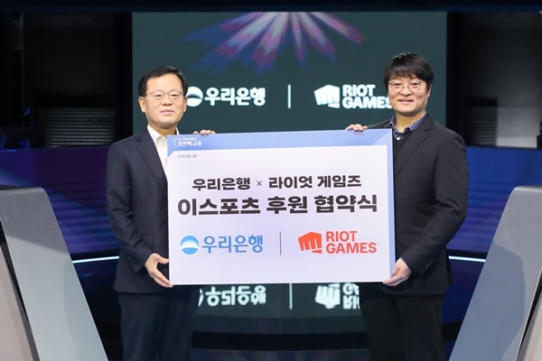 지난 30일 종로구 롤파크 이스포츠 경기장에서 진행된 이스포츠 후원 협약식에서 조병규 우리은행장(왼쪽)과 조혁진 라이엇 게임즈 코리아 대표가 기념사진을 촬영하고 있다. ⓒ 파이낸셜데일리 / 우리은행