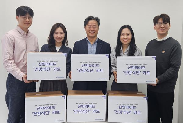 신한라이프빛나는재단 김순기 사무국장(가운데)과 신한라이프 임직원들이 결식 우려 아동에게 전달할 건강식단 키트와 함께 서 있다. ⓒ 파이낸셜데일리 / 신한라이프