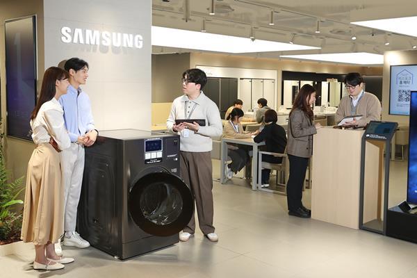 삼성전자 디테일러(제품 전문 상담사)가 올인원 세탁∙건조기 '비스포크 AI 콤보'와 함께 삼성스토어 '신모델 초대전'을 소개하고 있다. ⓒ 파이낸셜데일리 / 삼성전자