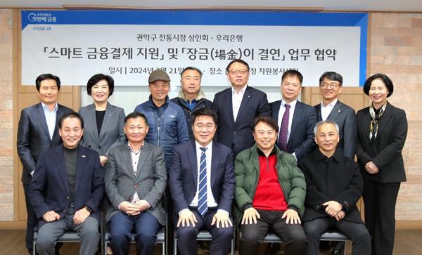 우리은행(은행장 조병규)이 지난 21일 관악구청 자원봉사센터에서 관악구 전통시장 상인회와 ‘스마트 금융결제 지원’ 과 ‘장금(場金)이 결연’ 업무협약을 체결했다. 관악구 전통시장 상인회 임영업 회장(앞줄 좌측 두번째), 박준희 관악구청장(앞줄 좌측 세번째), 우리은행 금융소비자보호그룹 정현옥 부행장(뒷줄 좌측 두번째), 우리은행 중소기업그룹 정진완 부행장(뒷줄 우측 네번째) 등 참석자들이 협약식에서 기념사진을 촬영하고 있다. ⓒ 파이낸셜데일리 / 우리은행