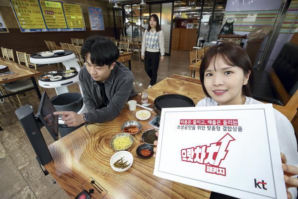 모델이 서울 종로구의 한 음식점에서 KT 으랏차차 패키지에 포함된 하이오더와 AI 서빙로봇을 소개하는 모습. ⓒ 파이낸셜데일리 / KT