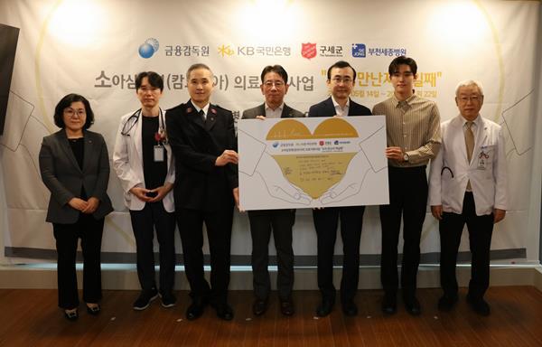 22일 부천 세종병원에서 열린 행사에 (좌측 3번째) 김병윤 구세군 서기장관, (좌측 4번째) 이재근 KB국민은행장, (좌측 5번째) 이세훈 금융감독원 수석부원장, (좌측 6번째) 김우민 KB금융그룹 후원 수영선수, (좌측 7번째) 이명묵 부천 세종병원장이 기념 사진을 촬영하고 있다. ⓒ 파인낸셜데일리 / KB국민은행