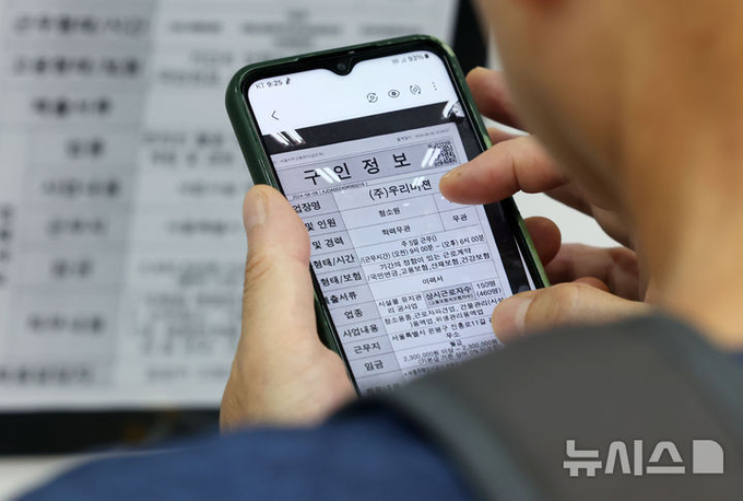 지난 19일 서울의 한 고용센터를 찾은 구직자가 스마트폰으로 찍은 일자리 정보 게시판을 살펴보고 있다. ⓒ 파이낸셜데일리 / 뉴시스