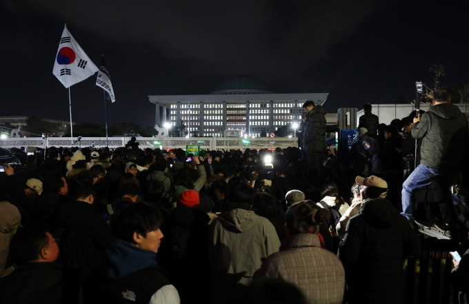 윤석열 대통령의 비상계엄 해제 요구 결의안이 국회 본회의에서 통과된 4일 새벽 서울 영등포구 국회 정문 앞에서 시민들이 윤석열 대통령 퇴진 촉구 구호를 외치고 있다. ⓒ 파이낸셜데일리 / 뉴시스