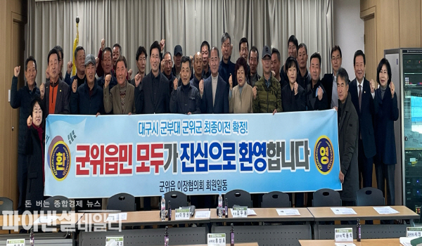 대구 군부대 통합 이전지로 최종 확정됨에 따라, 군위읍 이장협의회 회원들은 환영의 뜻을 담아 현수막을 들고 기념사진 ⓒ파이낸셜데일리/군위군