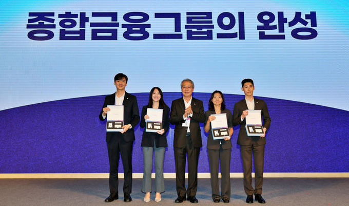 11일 서울 용산 드래곤시티에서 열린 '우리 WON Day' 행사에 참석한 임종룡 우리금융회장(가운데)이 동양·ABL생명 직원 대표 4명에게 그룹 사원증, 명함, 휘장이 담긴 비즈니스 키트를 수여하고 있다. ⓒ 파이낸셜데일리 / 우리금융